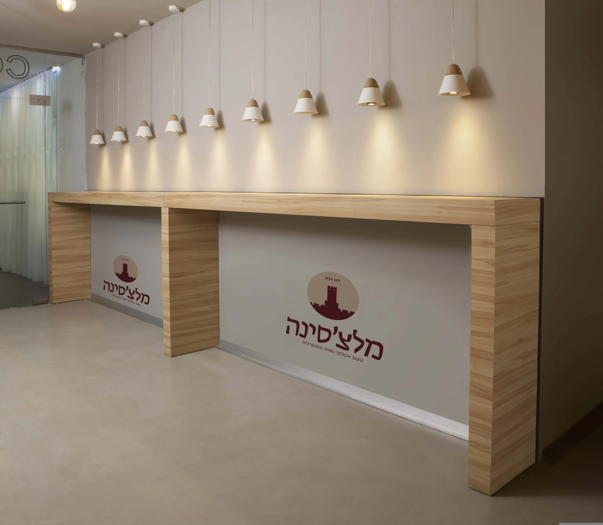הלוגו של מלצ'סינה על קיר הדלפק בחלל המסעדה